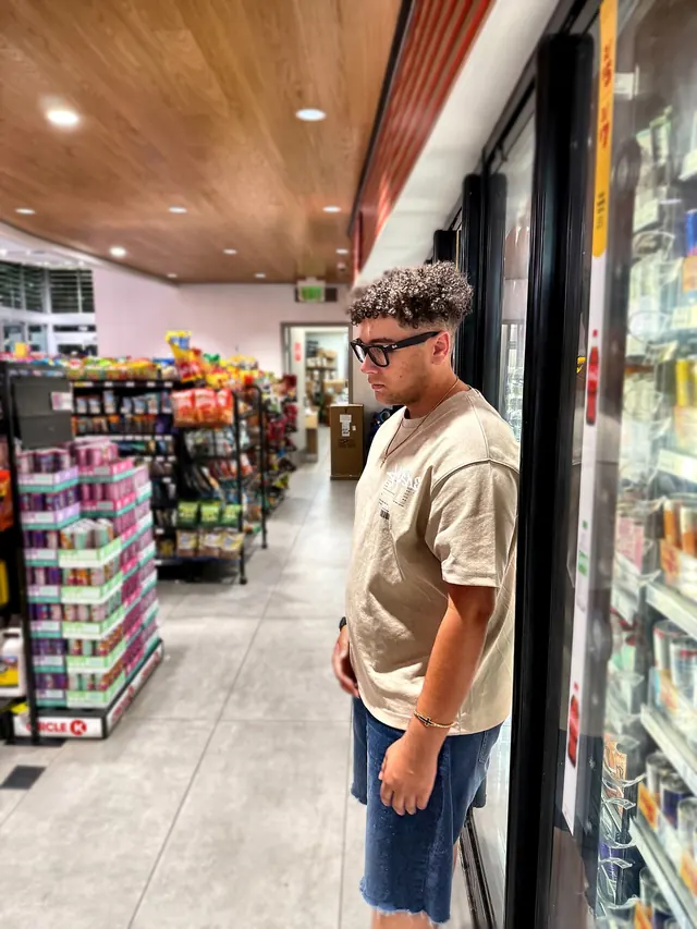 Will Smith leaning against the drink coolers in a corner store