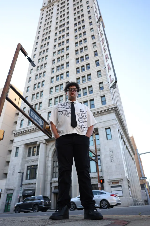 Low-angle full-body portrait of Will Smith in front of a historic downtown tower